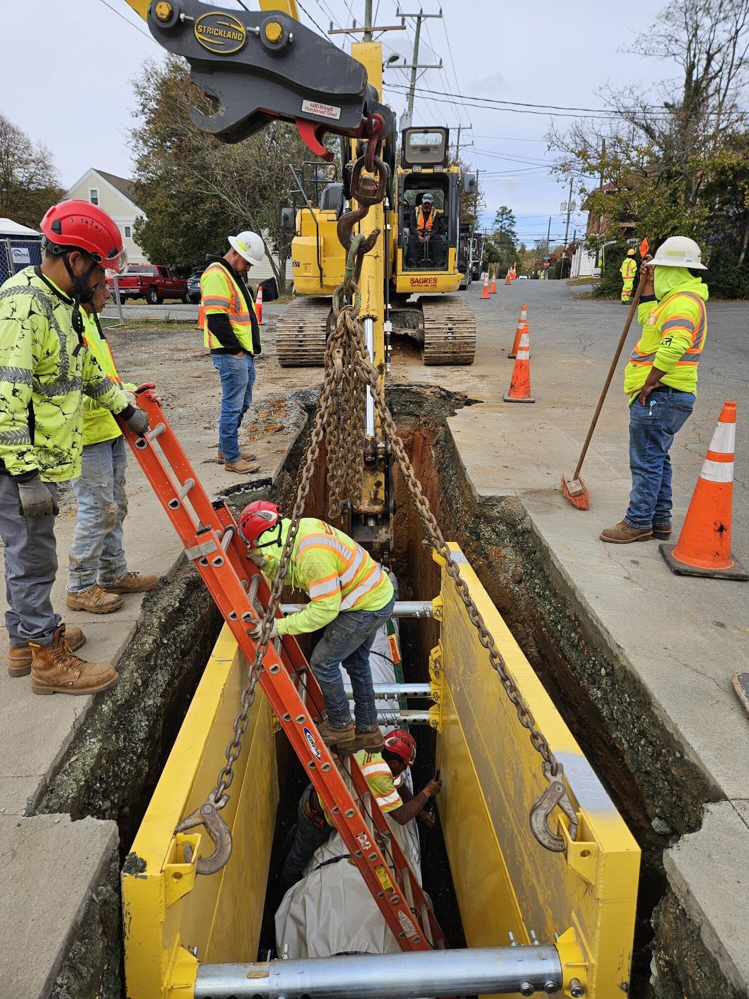 Construction crew installs the first piece of 24" pipe