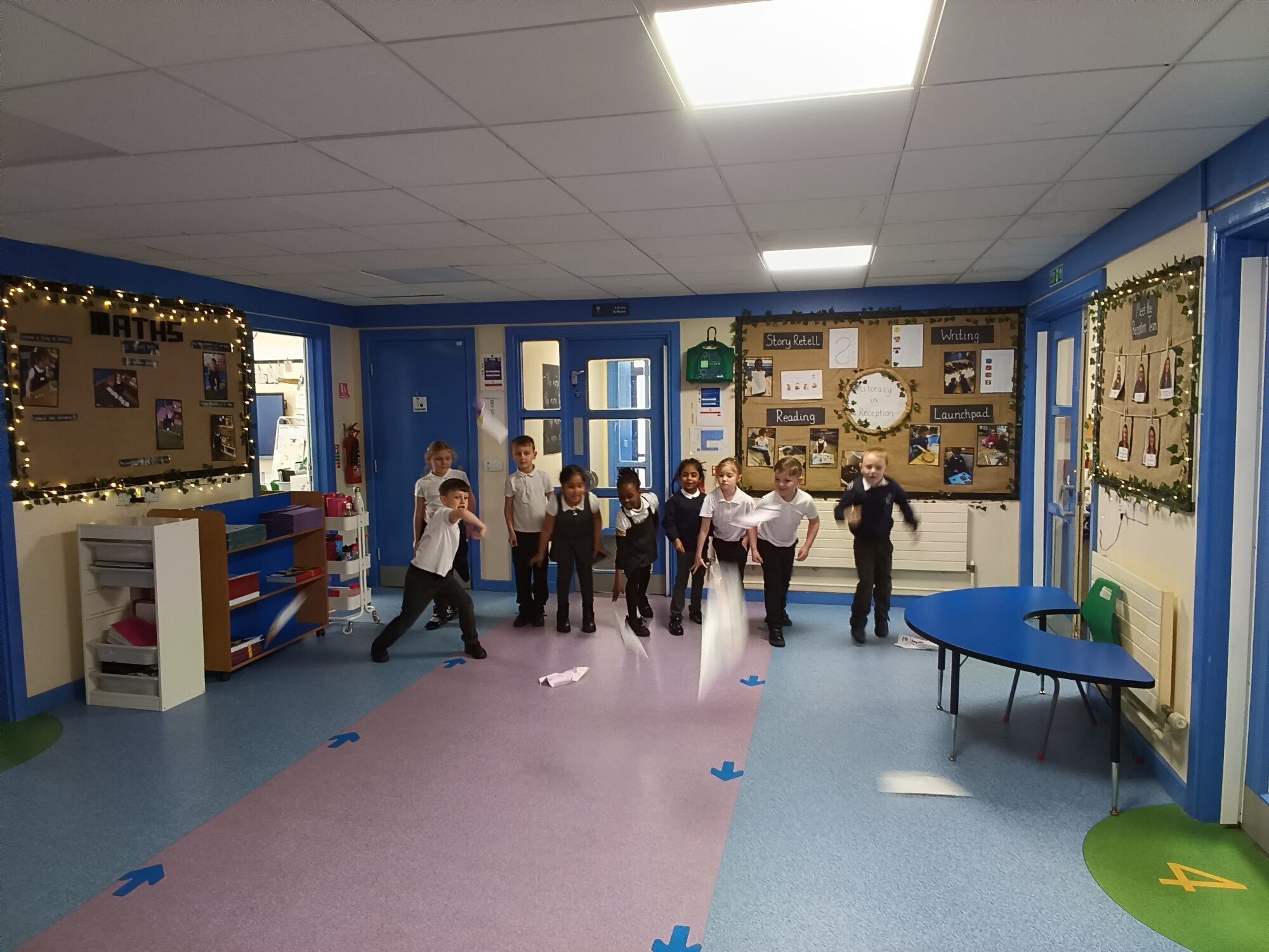 Six children with a tower of blocks taller than the whiteboard